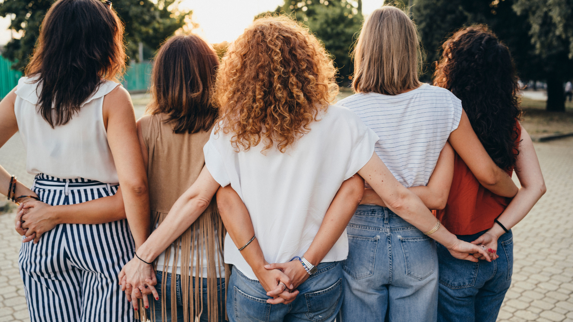 A group of women holding hands and looking out at the view