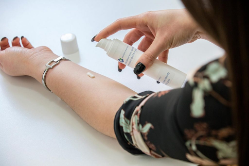 A woman applying cream to her arm