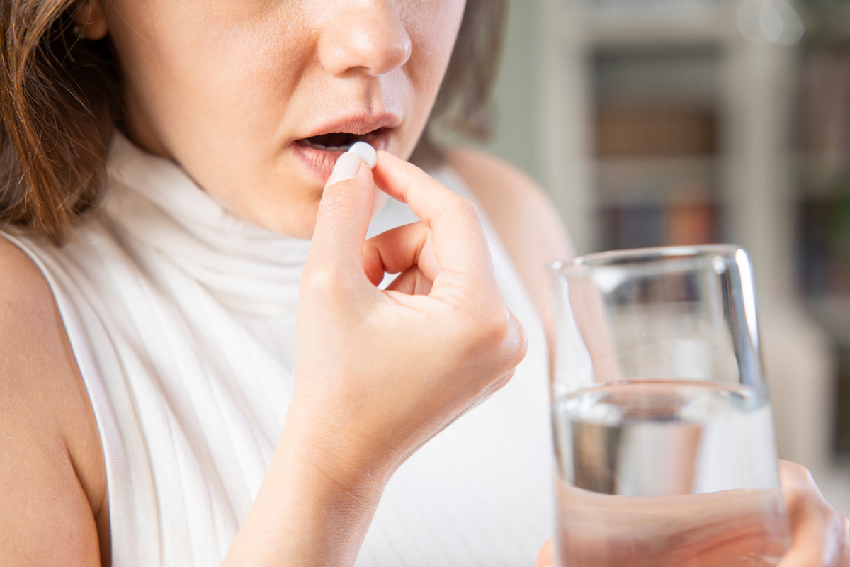 Woman taking pill with water